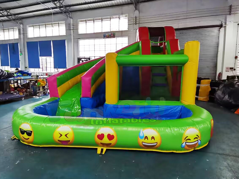 Los niños al aire libre del patio trasero van de fiesta el tobogán acuático inflable del emoji de lo
